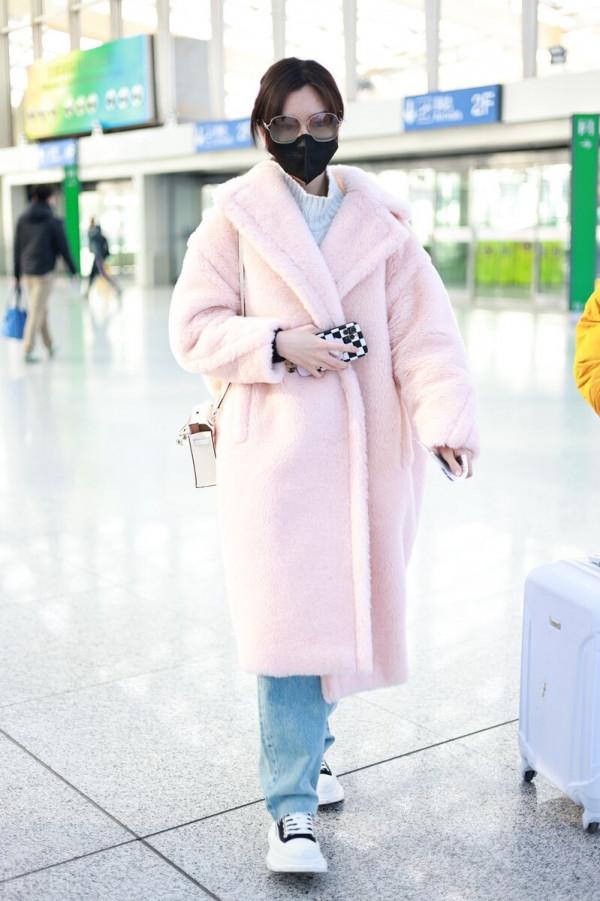 毛曉彤穿粉色毛呢大衣搭配牛仔褲，戴茶色墨鏡很時髦