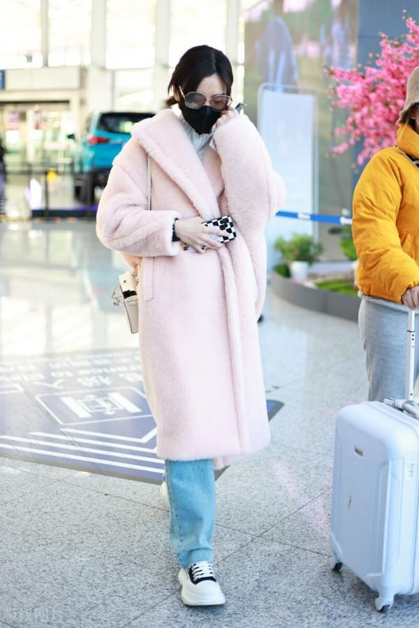 毛曉彤穿粉色毛呢大衣搭配牛仔褲，戴茶色墨鏡很時髦
