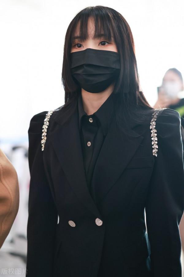 鄭乃馨穿黑色西裝搭配黑色百褶短裙，腳踩黑色短靴校園風十足