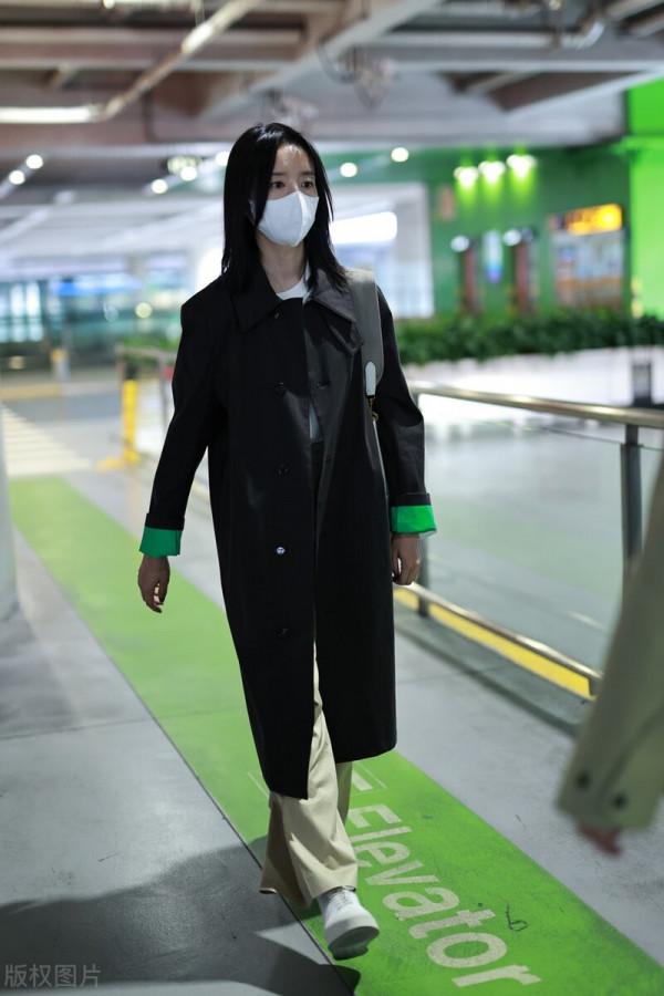 董潔穿黑色小翻領風衣搭配卡其色闊腿長褲，腳踩小白鞋休閒隨性