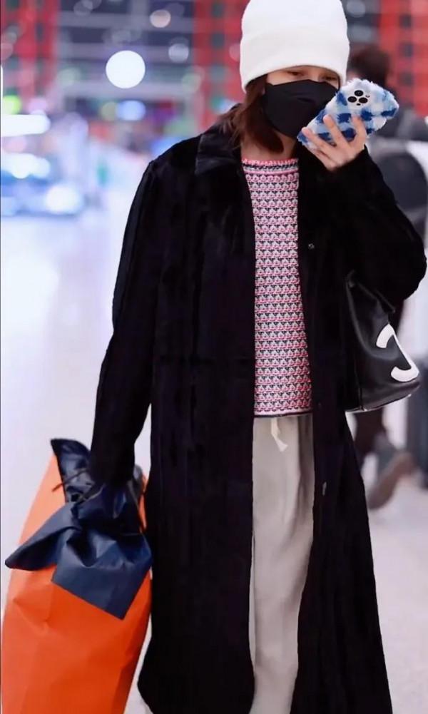 吳昕私服秀，身穿黑色大衣，揹著名牌包，身材超棒，忙著微信聊天