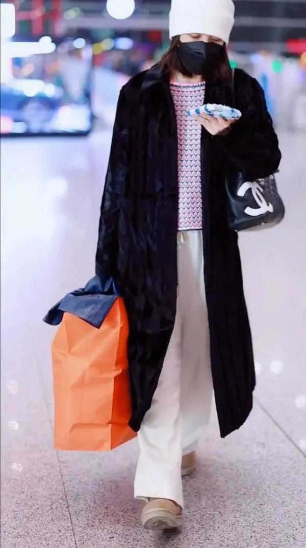 吳昕私服秀，身穿黑色大衣，揹著名牌包，身材超棒，忙著微信聊天