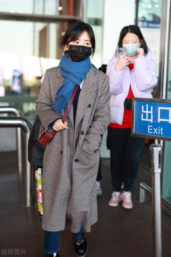 譚松韻穿格紋大衣搭配牛仔褲，系藍色圍巾，腳踩樂福鞋輕鬆隨性