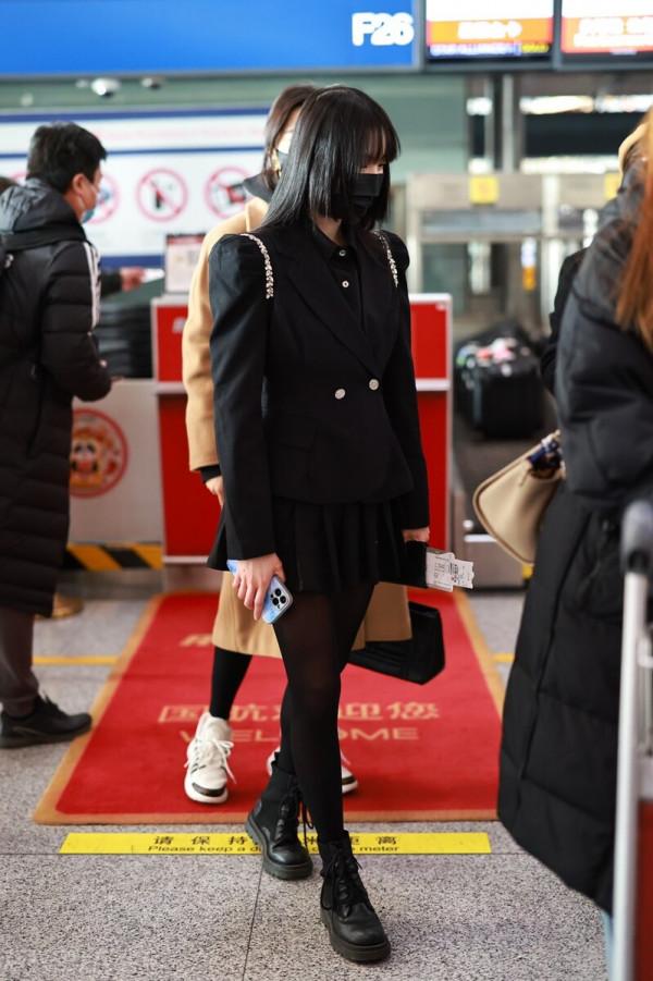 鄭乃馨穿黑色西裝搭配黑色百褶短裙，腳踩黑色短靴校園風十足