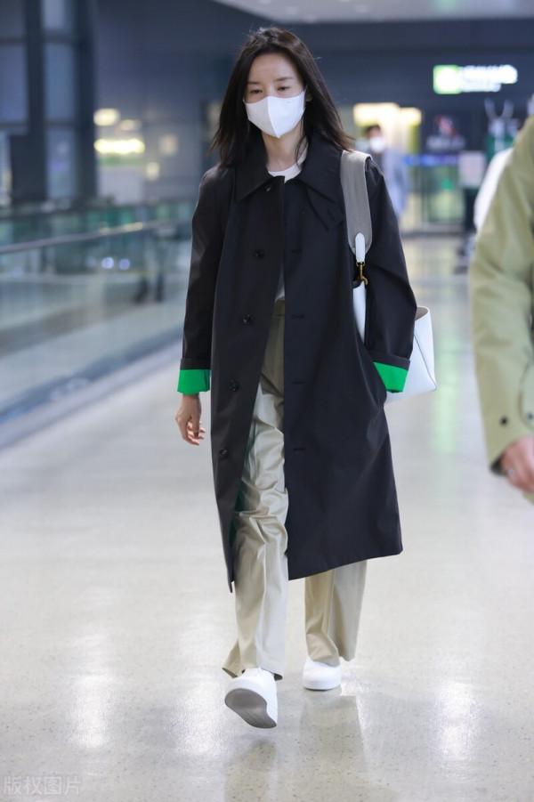 董潔穿黑色小翻領風衣搭配卡其色闊腿長褲，腳踩小白鞋休閒隨性