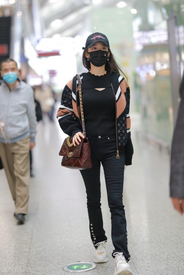 吉娜穿拼接拉鍊外套搭配黑色喇叭褲，單肩挎漆皮鏈條包很時髦