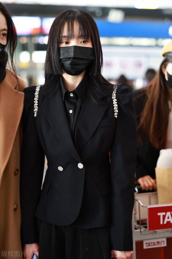 鄭乃馨穿黑色西裝搭配黑色百褶短裙，腳踩黑色短靴校園風十足