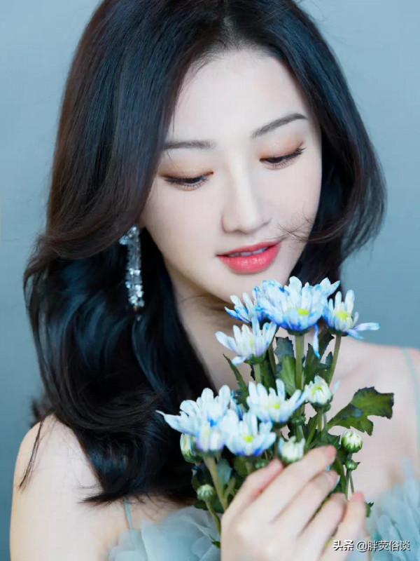 景甜一身綠色蛋糕裙，手捧一束鮮花，美麗優雅