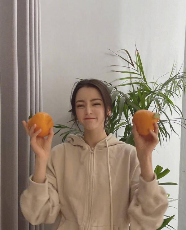 迪麗熱巴頭頂橘子拍照俏皮搞怪 托腮嘟嘴可愛滿分