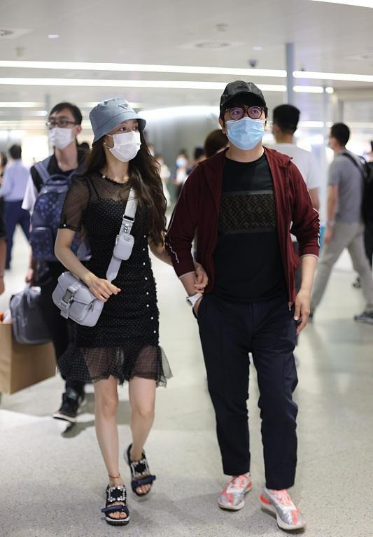 生娃後的吉娜不太自信，穿膝上波點裙走機場，挽著郎朗胳膊不撒手