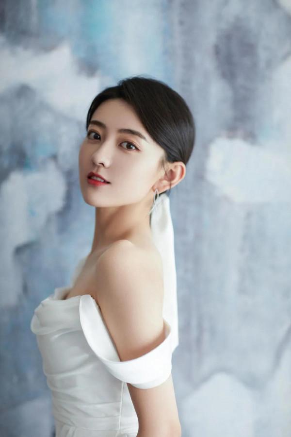 梁潔百褶裙氣質清雅，一頭微卷短髮精緻時髦，隨意撩耳後優雅美麗