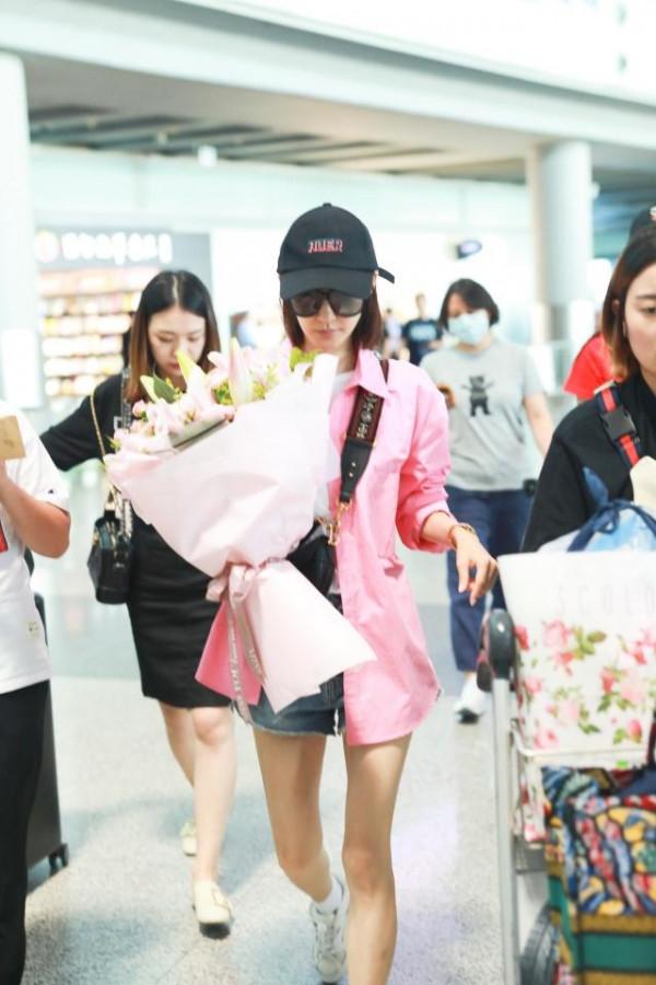 “素顏女神”王麗坤走機場，穿粉襯衫配牛仔短褲，瞬間嫩回十八歲