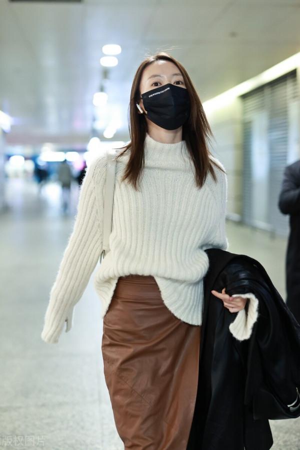 童瑤穿白色高領毛衣搭配棕色開衩皮裙，腳踩黑色長靴溫柔優雅