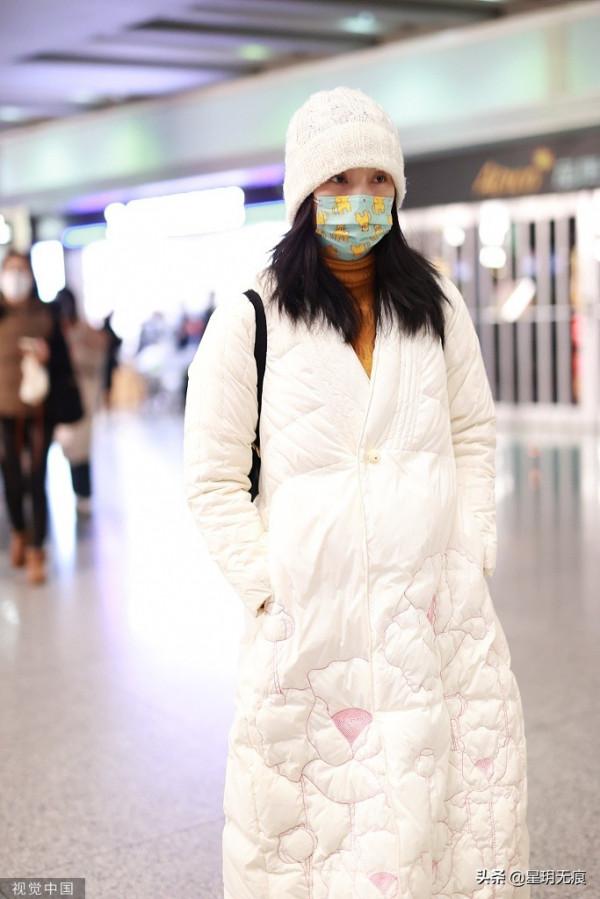 陶虹穿白色刺繡羽絨服趕飛機 戴卡通口罩難掩笑容