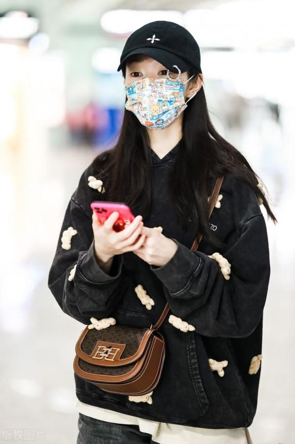 宋軼穿黑色衛衣搭配灰色牛仔褲，斜挎包袋活力少女感
