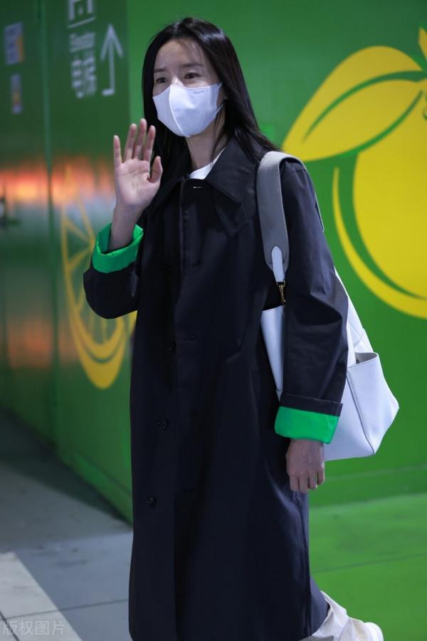 董潔穿黑色小翻領風衣搭配卡其色闊腿長褲，腳踩小白鞋休閒隨性