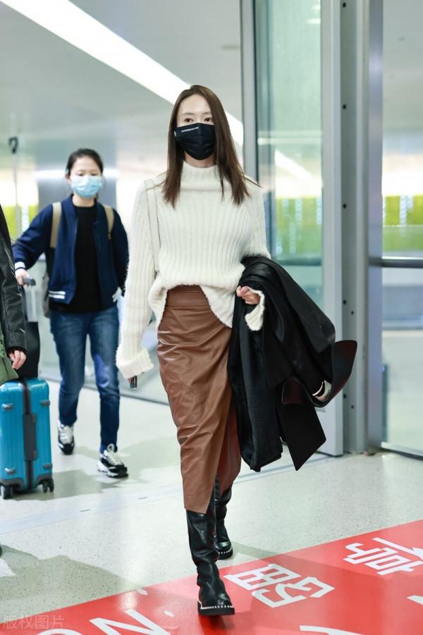 童瑤穿白色高領毛衣搭配棕色開衩皮裙，腳踩黑色長靴溫柔優雅