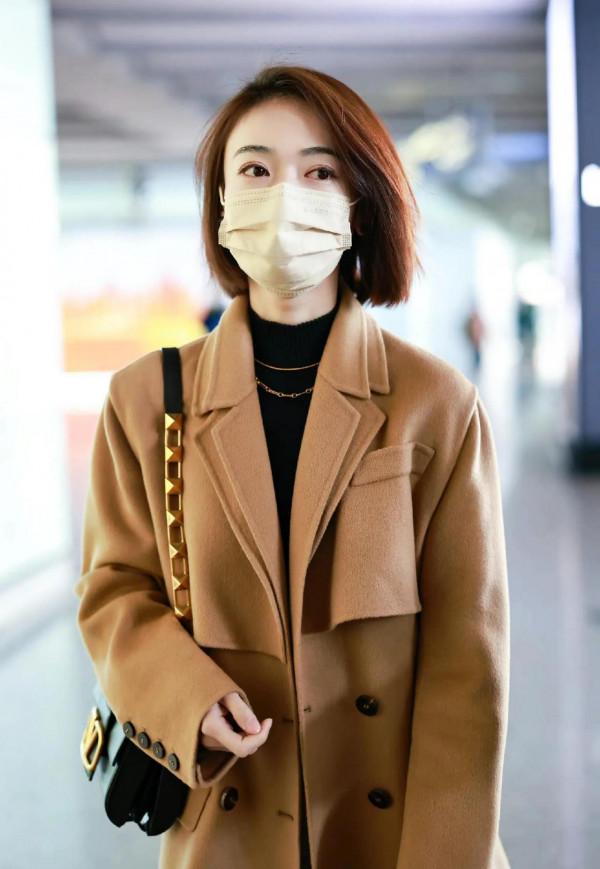 吳謹言私服，身穿呢子大衣腳套大長靴，靴子比包包還要亮