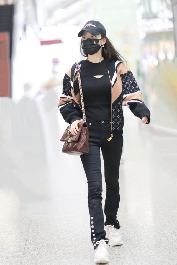 吉娜穿拼接拉鍊外套搭配黑色喇叭褲，單肩挎漆皮鏈條包很時髦