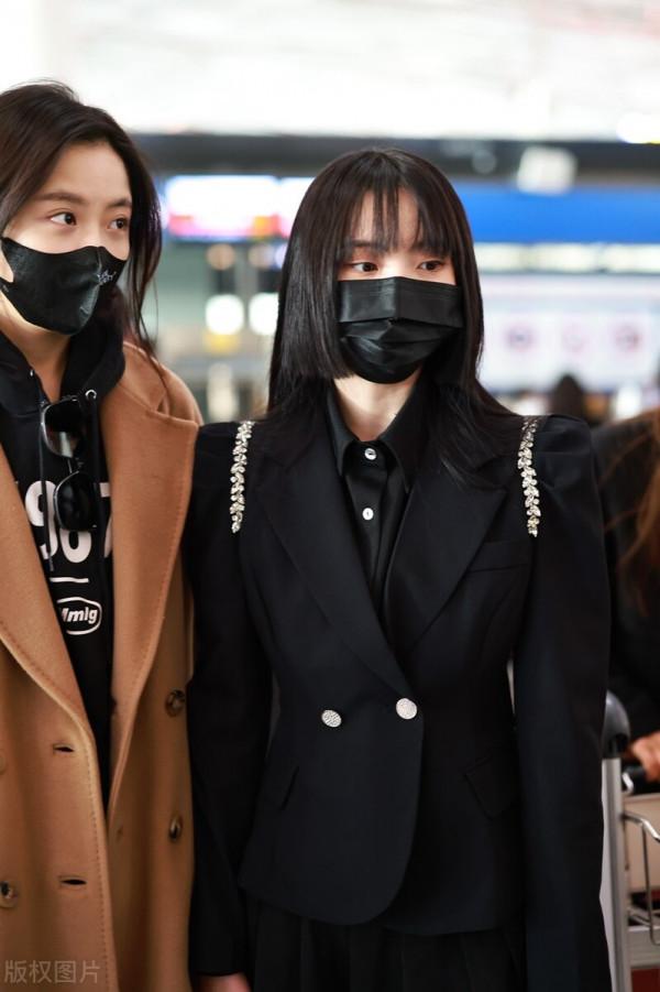 鄭乃馨穿黑色西裝搭配黑色百褶短裙，腳踩黑色短靴校園風十足