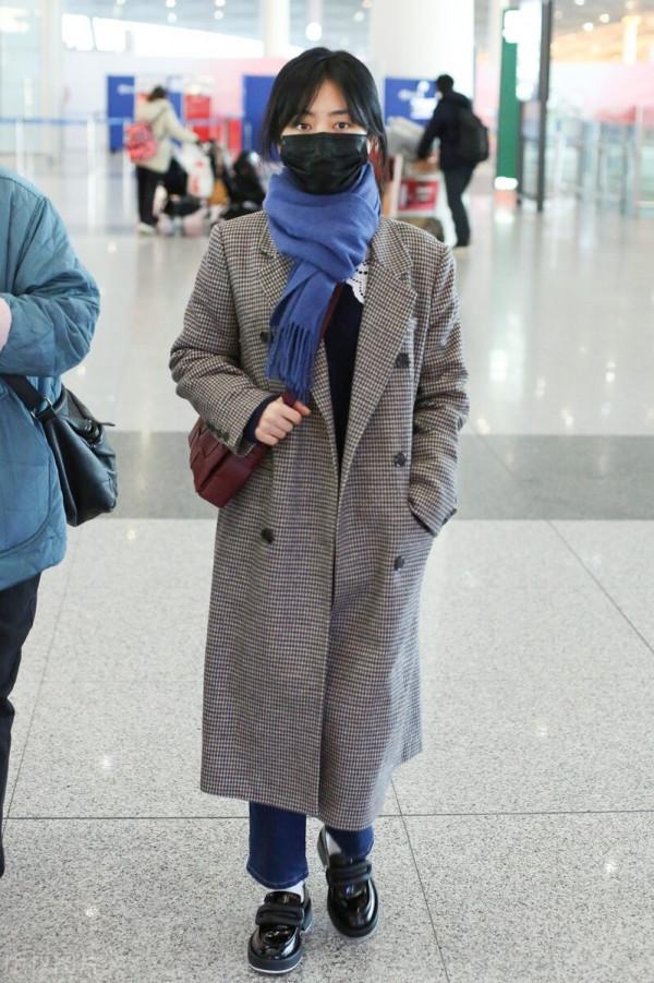 譚松韻穿格紋大衣搭配牛仔褲，系藍色圍巾，腳踩樂福鞋輕鬆隨性