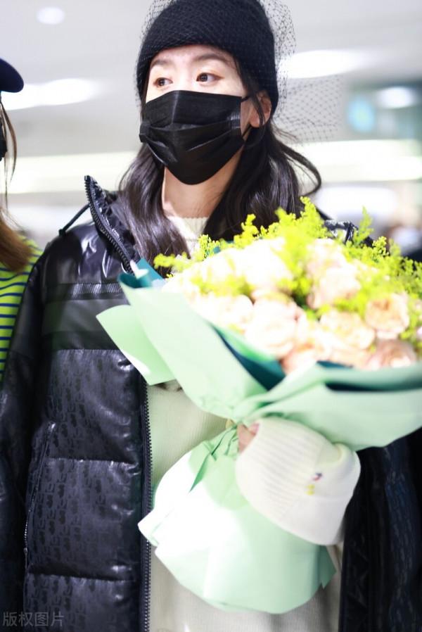 袁冰妍穿羽絨服搭配牛仔褲，腳踩毛絨拖鞋，戴網紗毛線帽很時髦