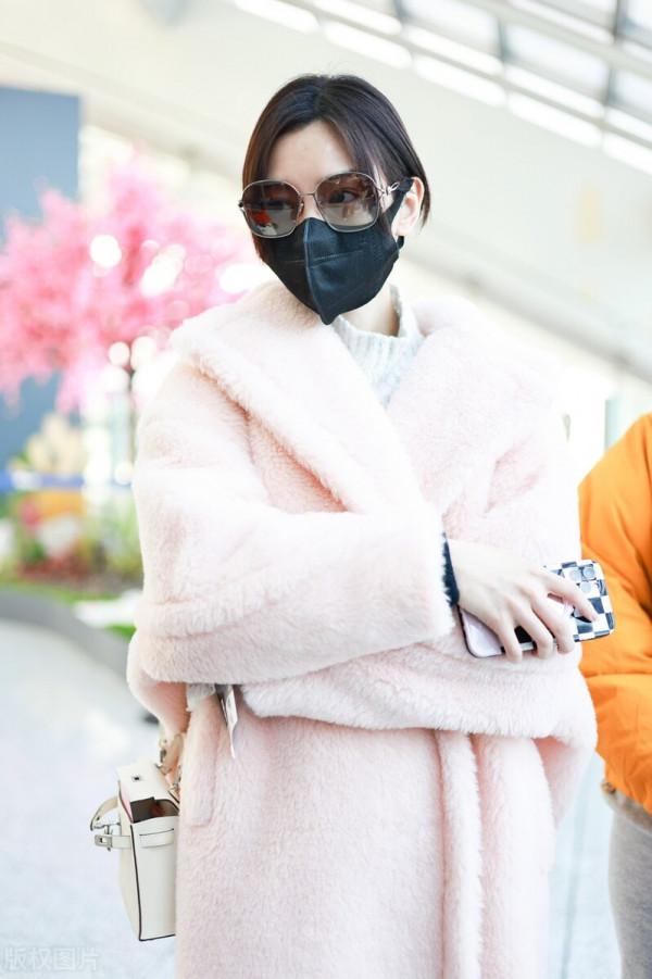 毛曉彤穿粉色毛呢大衣搭配牛仔褲，戴茶色墨鏡很時髦
