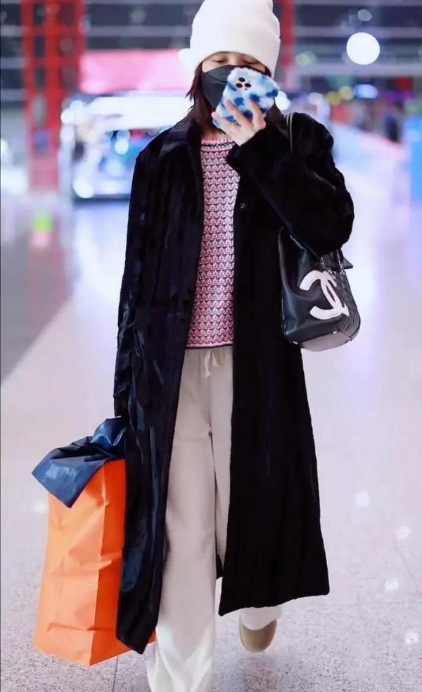 吳昕私服秀，身穿黑色大衣，揹著名牌包，身材超棒，忙著微信聊天