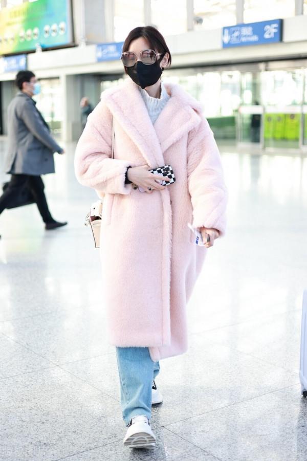 毛曉彤穿粉色毛呢大衣搭配牛仔褲，戴茶色墨鏡很時髦