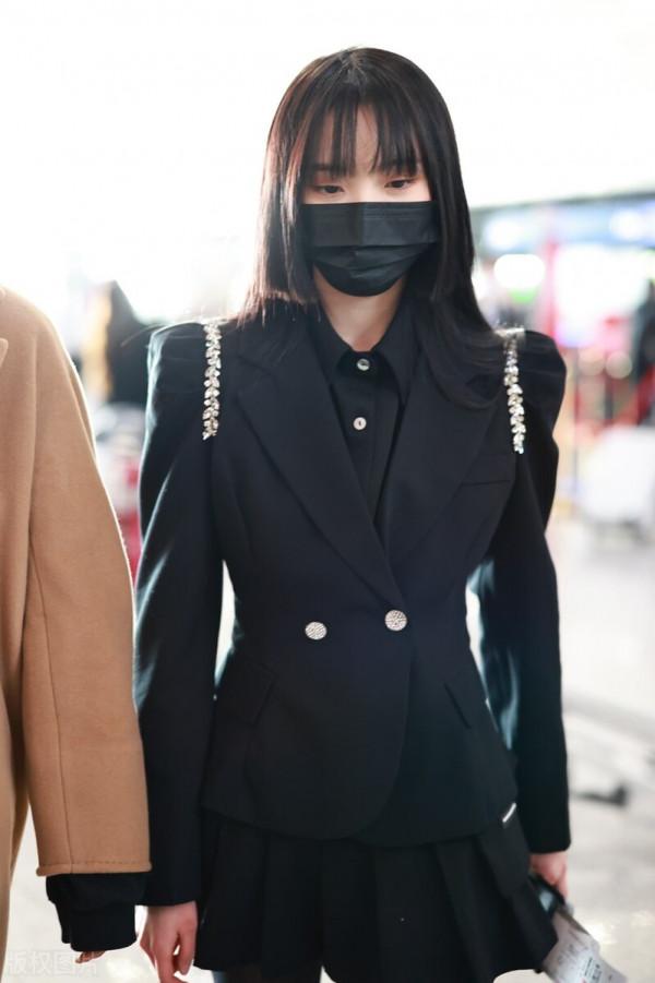 鄭乃馨穿黑色西裝搭配黑色百褶短裙，腳踩黑色短靴校園風十足