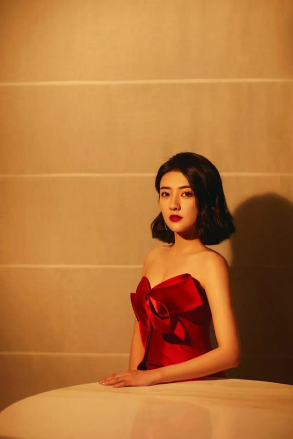 梁潔百褶裙氣質清雅，一頭微卷短髮精緻時髦，隨意撩耳後優雅美麗