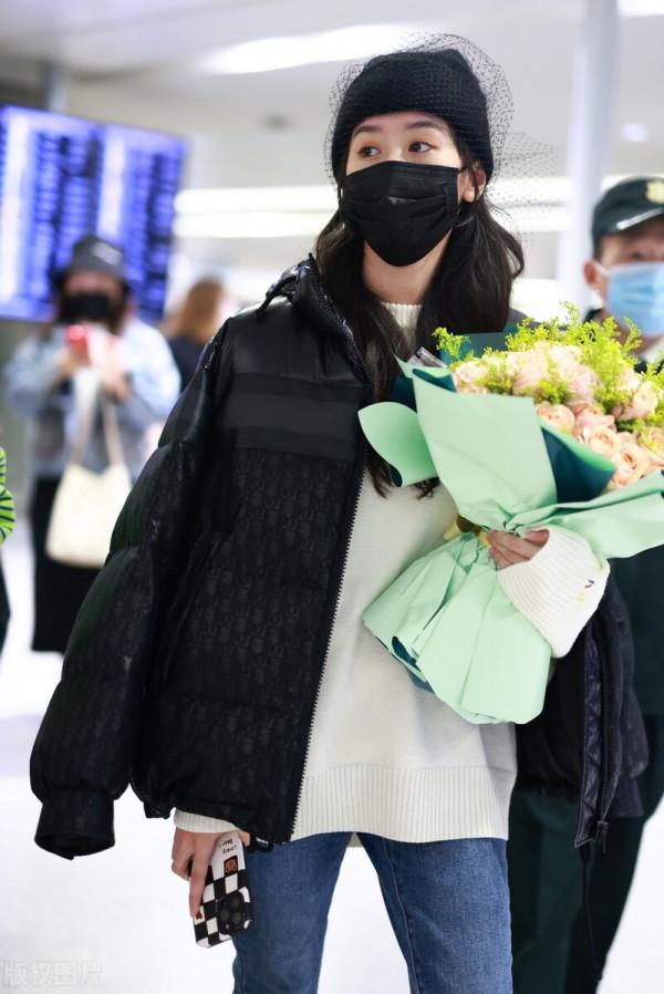袁冰妍穿羽絨服搭配牛仔褲，腳踩毛絨拖鞋，戴網紗毛線帽很時髦