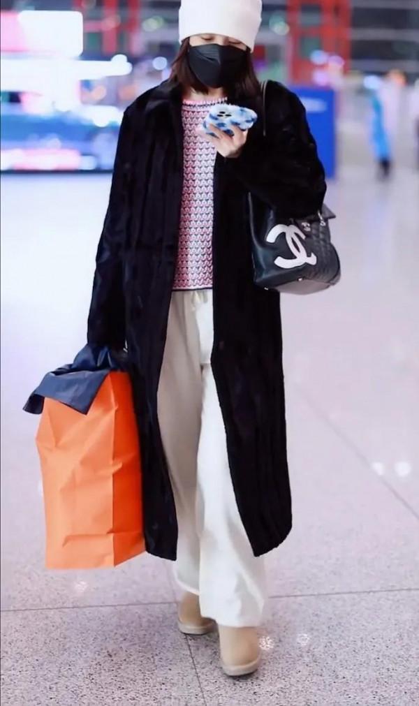 吳昕私服秀，身穿黑色大衣，揹著名牌包，身材超棒，忙著微信聊天