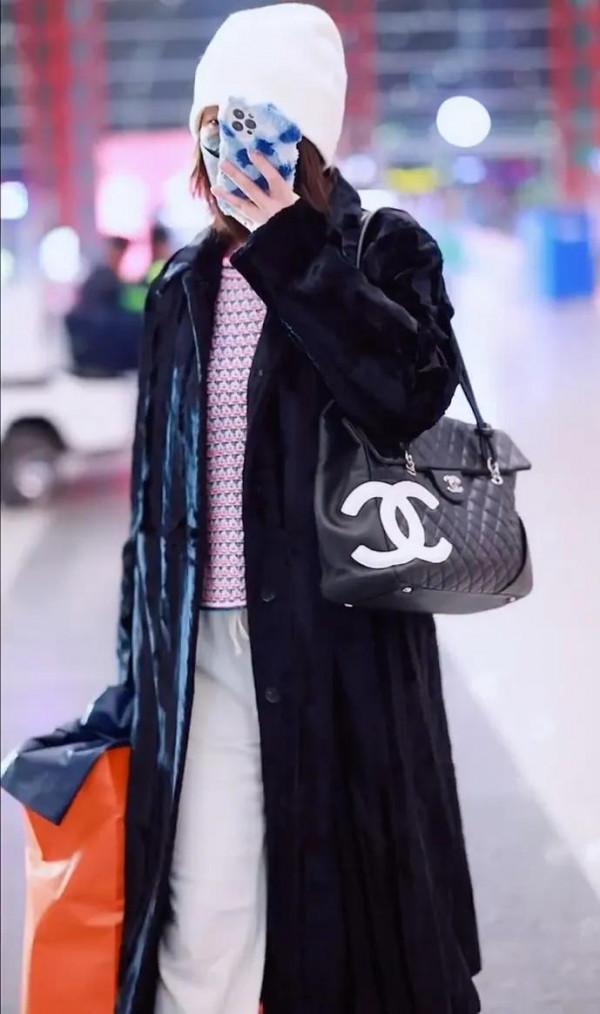 吳昕私服秀，身穿黑色大衣，揹著名牌包，身材超棒，忙著微信聊天