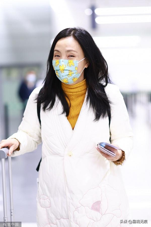 陶虹穿白色刺繡羽絨服趕飛機 戴卡通口罩難掩笑容