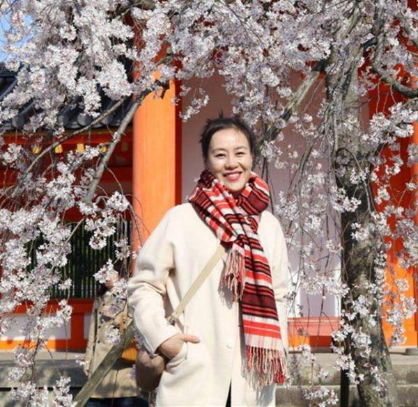 鄔君梅跟男演員合影，55歲容顏自然真實，穿大衣氣質端莊優雅