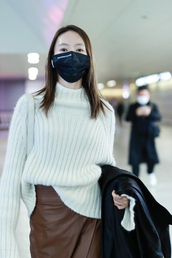 童瑤穿白色高領毛衣搭配棕色開衩皮裙，腳踩黑色長靴溫柔優雅